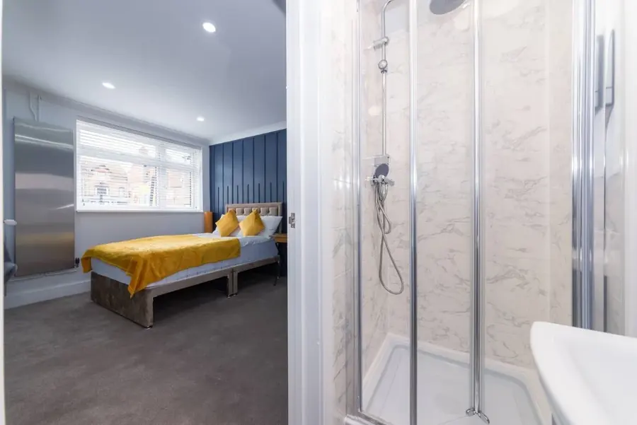 A bedroom with a private ensuite shower room
