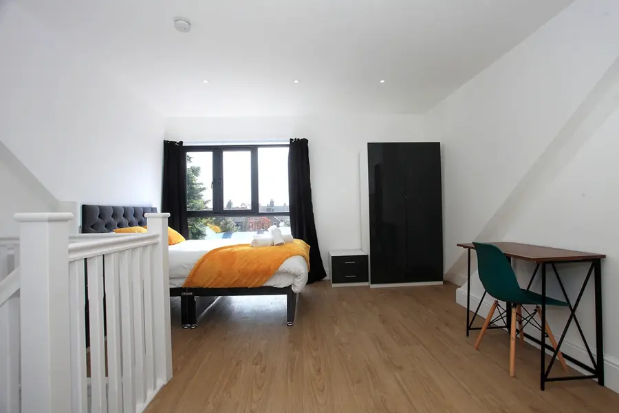 A room with a desk, chair and wardrobe, set up for working away from the office